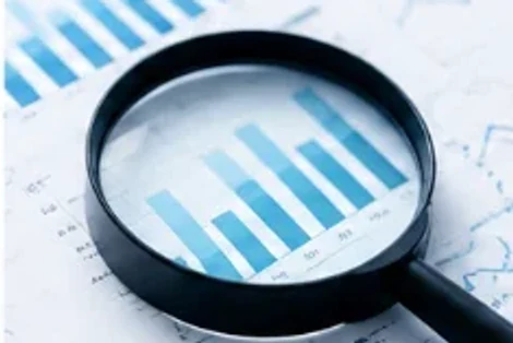 Magnifying glass over a bar chart, examining the data closely